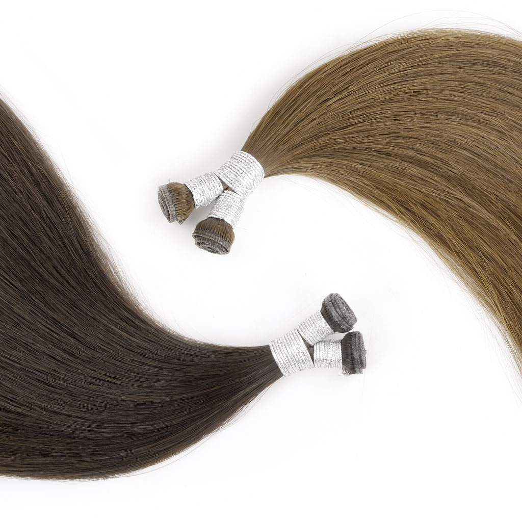 Two bundles of GENIUS WEFT Hair Extensions 7-Star Full Cuticle Remy Hair in a yin-yang patterned arrangement